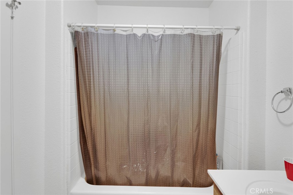 12887 Sholic Road Apple Valley, CA 92308 - Photo 19 of 47 a bathroom with a shower curtain and a window