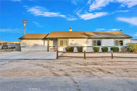 a white house with a big yard and large trees