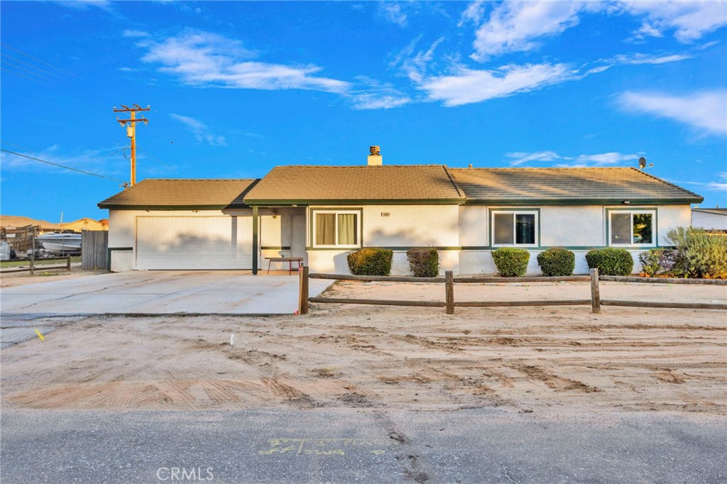 12887 Sholic Road Apple Valley, CA 92308 - Photo 2 of 47 a white house with a big yard and large trees