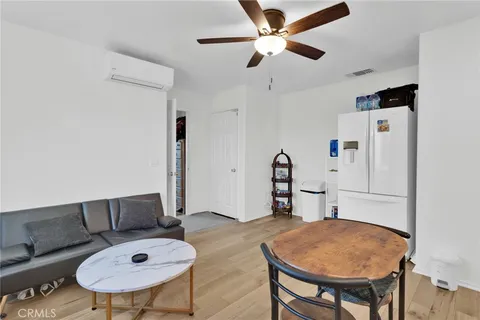a living room with furniture and a dining table with wooden floor