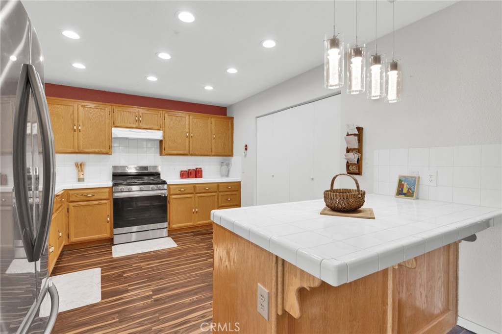 12887 Sholic Road Apple Valley, CA 92308 - Photo 8 of 47 a kitchen with a sink a kitchen island and stainless steel appliances