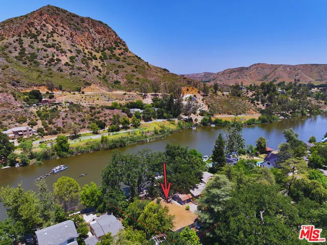 an aerial view of lake residential house with outdoor space and trees all around