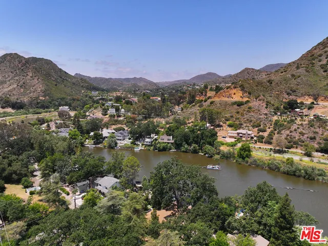 an aerial view of residential houses with outdoor space and lake view