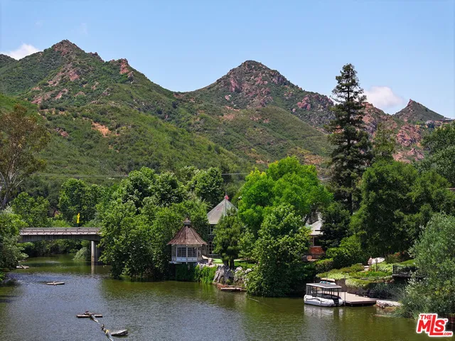 a view of a house with a yard and a pond