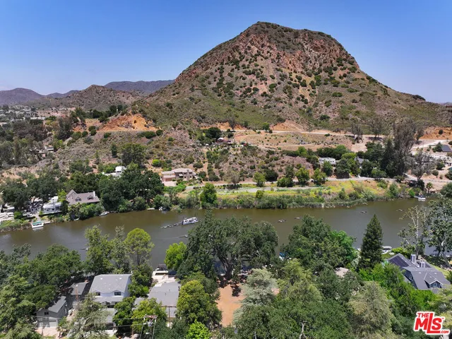 an aerial view of residential houses with outdoor space and lake view