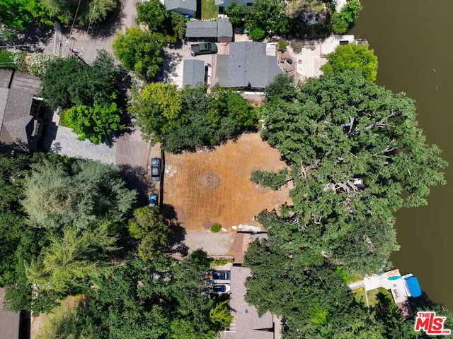 an aerial view of a house with a yard and lake view