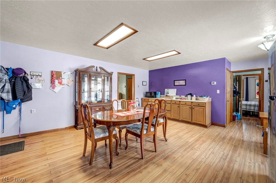 3830 Jerusalem Road Vermilion, OH 44089 - Photo 17 of 49 Dining space featuring light wood-style flooring and a textured ceiling