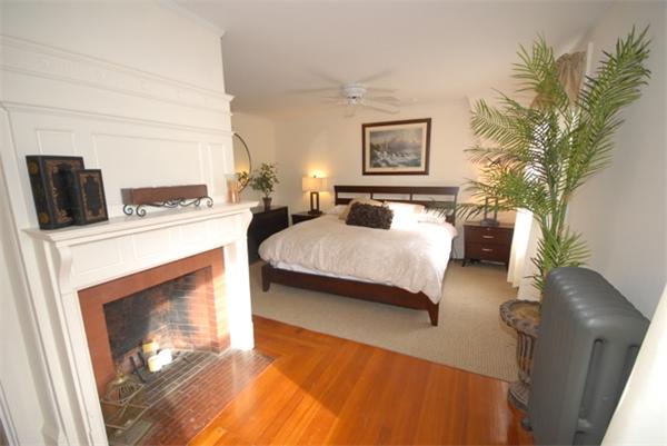 43 Bartlet Street Andover, MA 01810 - Photo 14 of 30 a bedroom with a bed and a fireplace