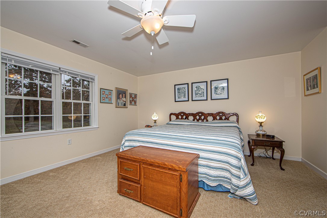 24410 Johnson Road Jetersville, VA 23083 - Photo 13 of 47 a spacious bedroom with a bed and a chandelier