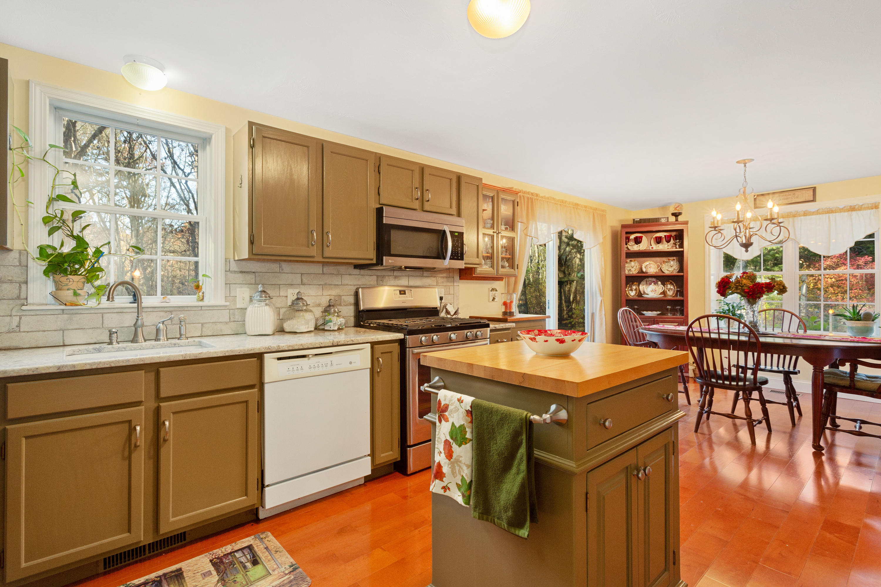 70 South Precinct Road Centerville, MA 02632 - Photo 13 of 32 a kitchen with stainless steel appliances granite countertop a stove top oven a sink dishwasher and white cabinets with wooden floor