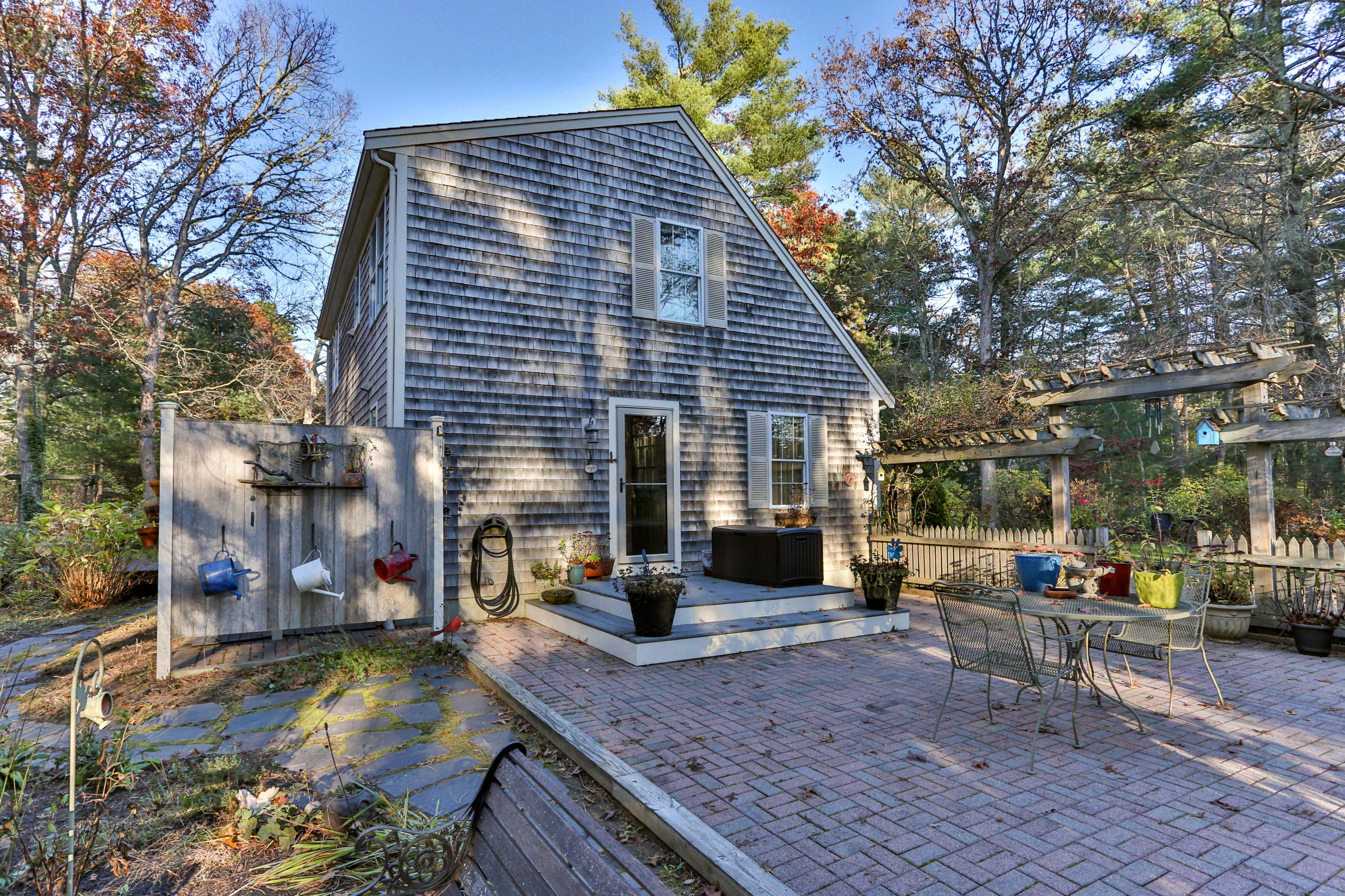 70 South Precinct Road Centerville, MA 02632 - Photo 25 of 32 a view of a house with patio chairs and a fire pit