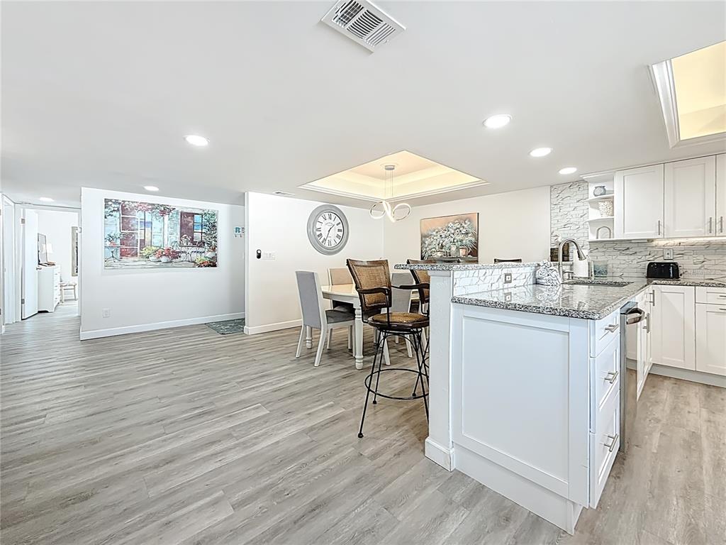 19725 Gulf Boulevard, Unit 46 Indian Rocks Beach, FL 33785 - Photo 15 of 55 a kitchen with stainless steel appliances granite countertop a table chairs refrigerator and sink