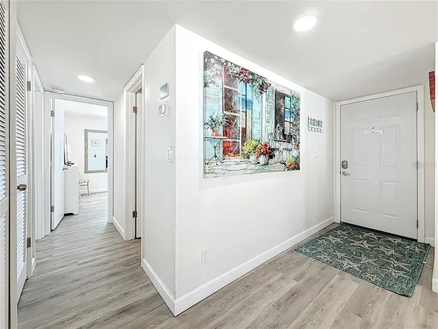 a kitchen with cabinets stainless steel appliances and wooden floor