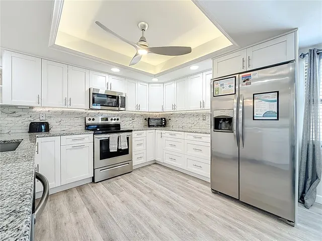 a kitchen with stainless steel appliances granite countertop a stove a sink and a microwave