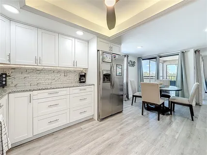 a kitchen with cabinets stainless steel appliances and wooden floor