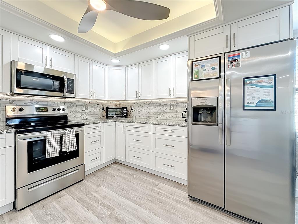 19725 Gulf Boulevard, Unit 46 Indian Rocks Beach, FL 33785 - Photo 20 of 55 a kitchen with cabinets stainless steel appliances and wooden floor