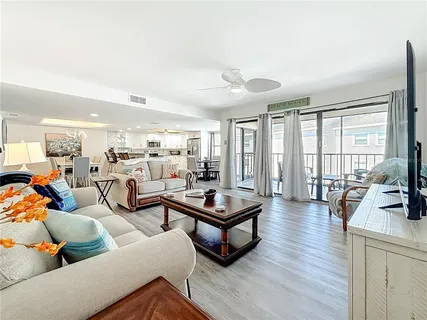 a living room with furniture and a flat screen tv with wooden floor