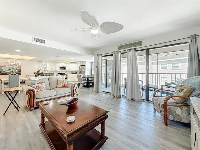 a living room with furniture and a flat screen tv with wooden floor