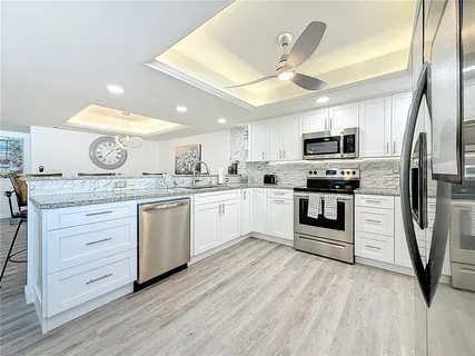 a spacious bedroom with a large bed and a chandelier