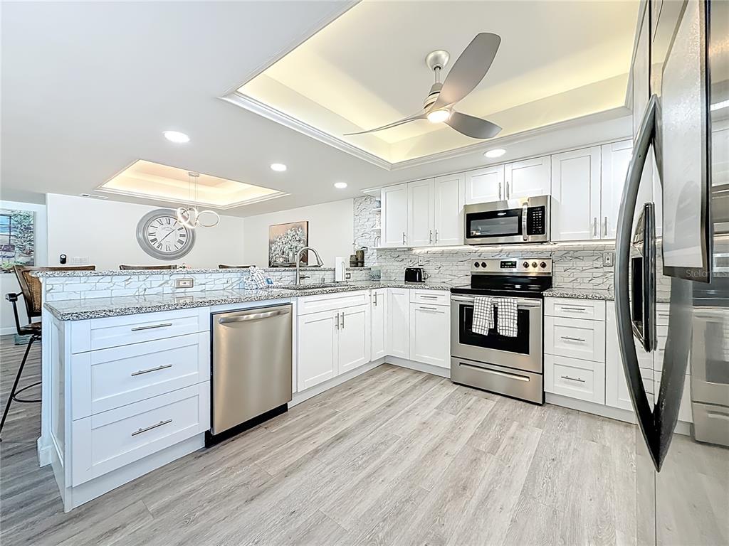 19725 Gulf Boulevard, Unit 46 Indian Rocks Beach, FL 33785 - Photo 22 of 55 a kitchen with kitchen island granite countertop a sink appliances cabinets and a counter space