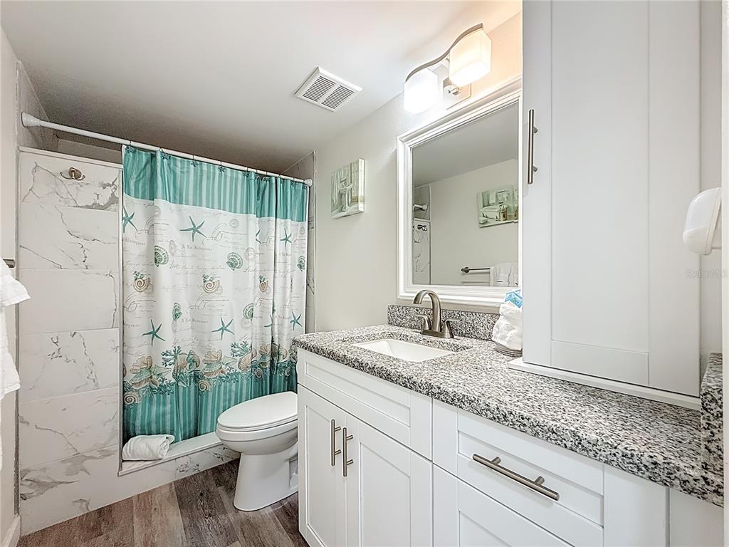 19725 Gulf Boulevard, Unit 46 Indian Rocks Beach, FL 33785 - Photo 26 of 55 a bathroom with a granite countertop sink a toilet and shower