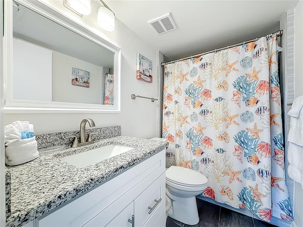 19725 Gulf Boulevard, Unit 46 Indian Rocks Beach, FL 33785 - Photo 28 of 55 a bathroom with a granite countertop sink and a mirror