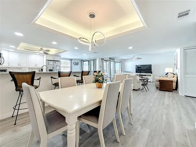 a kitchen with stainless steel appliances kitchen island granite countertop a table chairs and a refrigerator