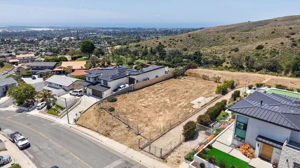an aerial view of a house with a mountain