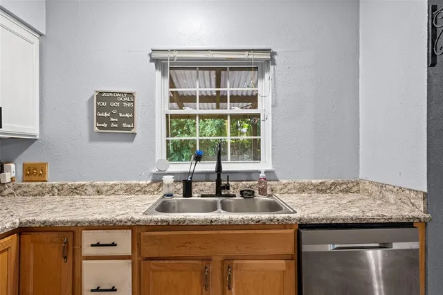 a kitchen with granite countertop a sink and a window