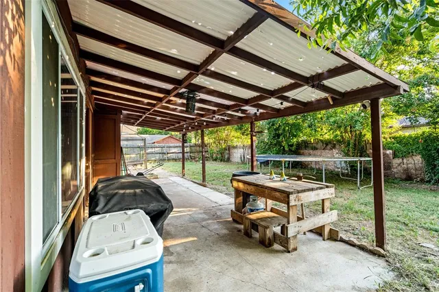 a backyard of a house with barbeque oven table and chairs