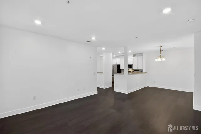 a view of kitchen with kitchen island a sink wooden floor and a refrigerator