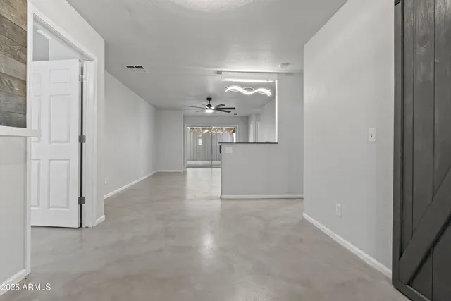 an empty room with ceiling fan and window