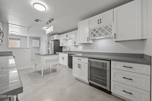 a kitchen with stainless steel appliances granite countertop a refrigerator a stove and a sink