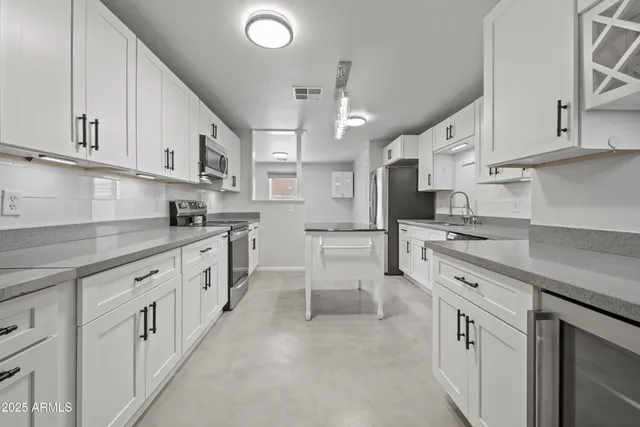 a kitchen with stainless steel appliances granite countertop a refrigerator sink and cabinets