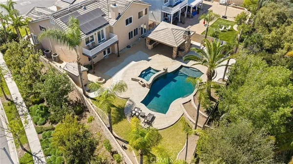an aerial view of a house with swimming pool and garden