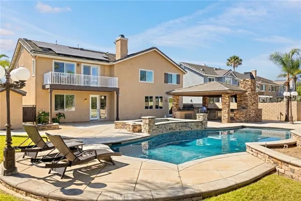 a view of a house with swimming pool and sitting area
