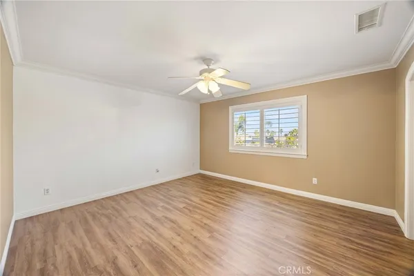 an empty room with windows and fan