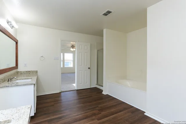 a view of a bathroom with wooden floor and a sink