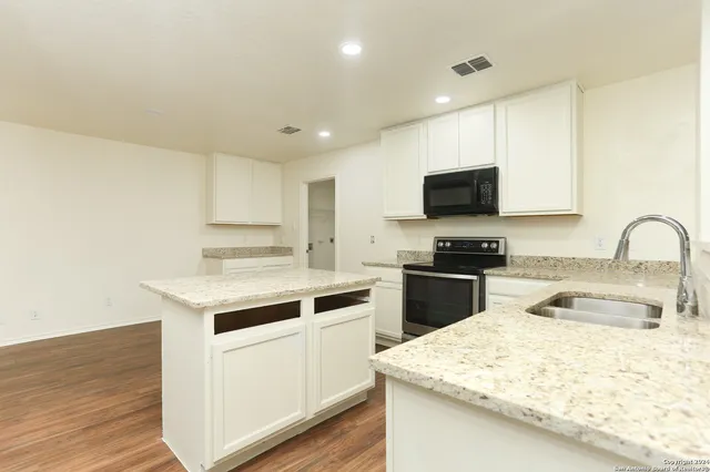 a kitchen with a sink stove and microwave