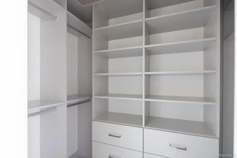 a view of walk in closet with empty racks