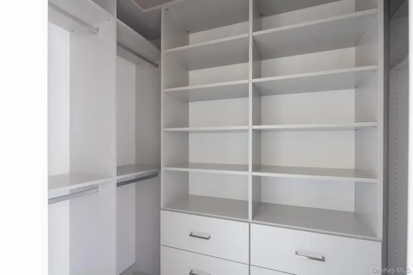 a view of walk in closet with empty racks