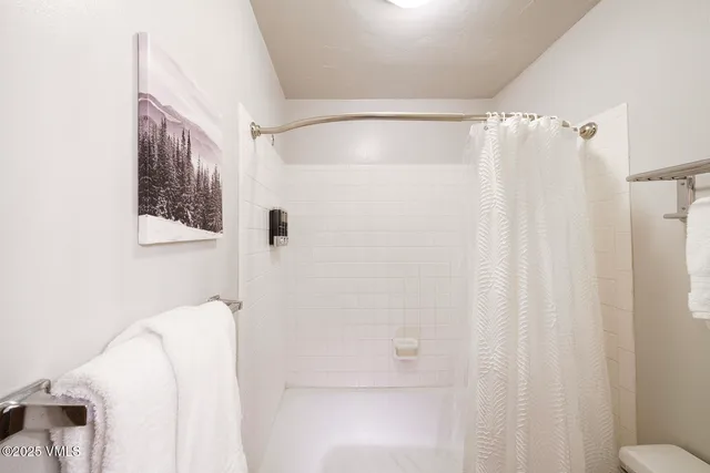 a bathroom with a shower curtain and a window