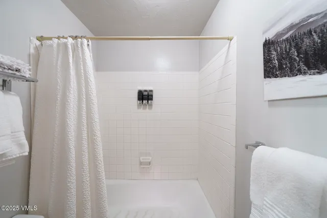 a bathroom with a shower curtain and a window