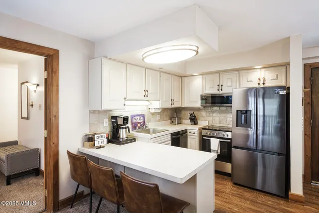 a kitchen with refrigerator cabinets dining table and chairs
