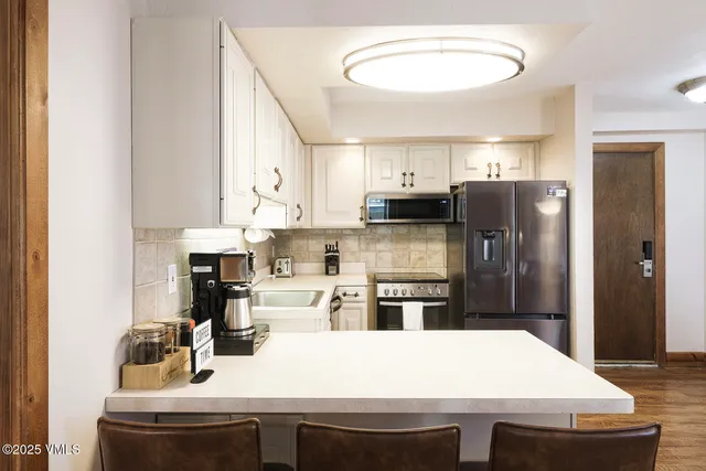 a kitchen with stainless steel appliances a refrigerator sink stove microwave and cabinets