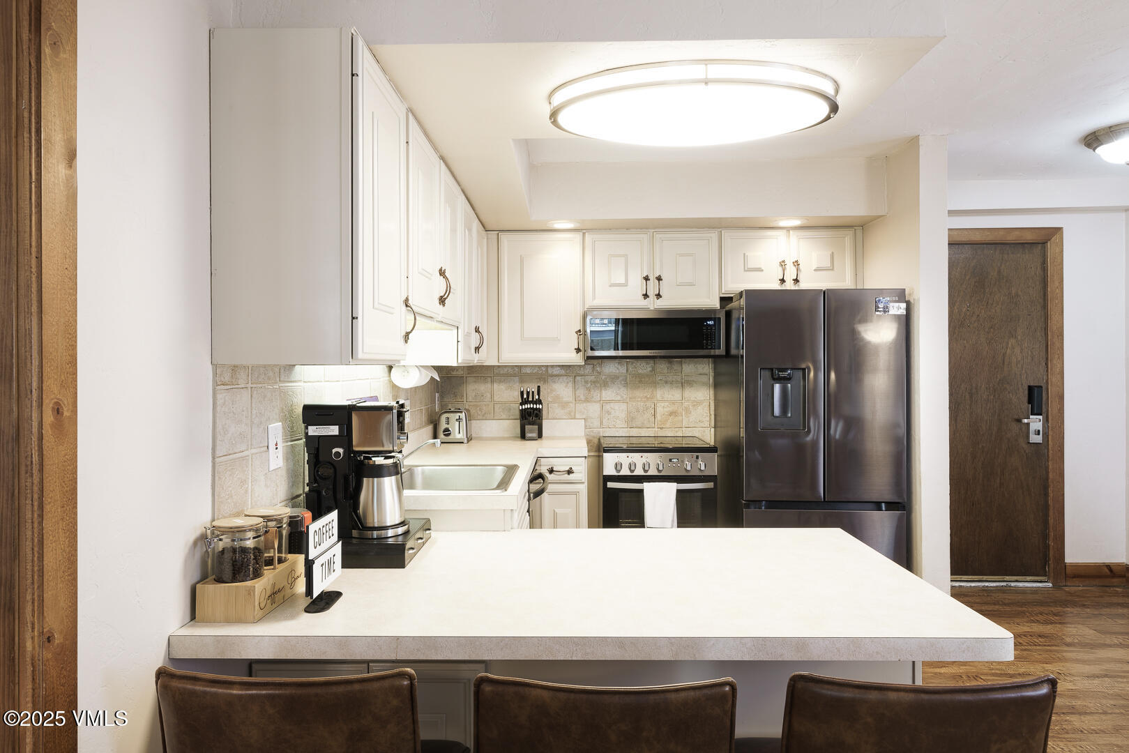 548 South Frontage Road West, Unit 301 Vail, CO 81657 - Photo 5 of 32 a kitchen with stainless steel appliances a refrigerator sink stove microwave and cabinets
