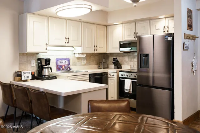 a kitchen with a refrigerator a stove a sink and cabinets