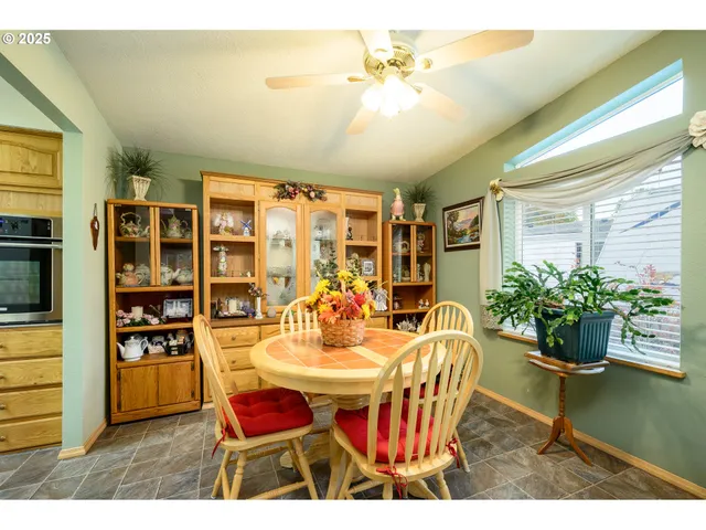 a dining room with stainless steel appliances kitchen island granite countertop furniture and a potted plant