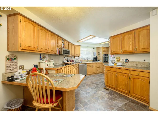a kitchen with stainless steel appliances granite countertop a sink a stove and a refrigerator