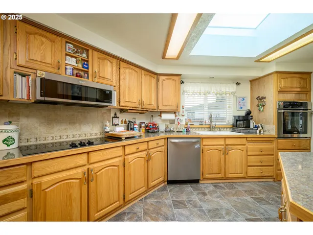 a kitchen with stainless steel appliances granite countertop a sink and cabinets